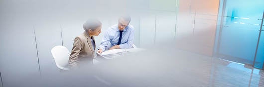 Two people reviewing a document in a conference room