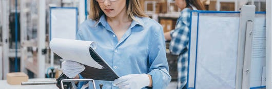 Technician in a lab reviewing notes