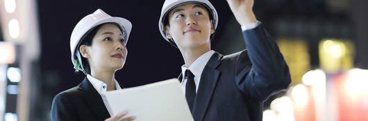 Two people in hardhats interacting