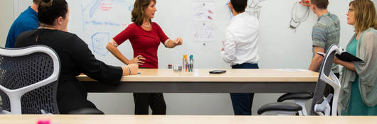 People gathered around a whiteboard having a meeting