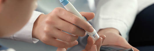 Doctor administering a blood sugar test on a patient