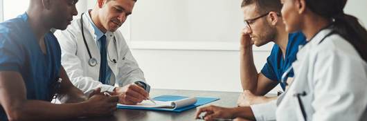 Doctors sitting at a table discussing notes