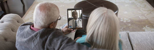 Two people having a virtual visit with their doctor