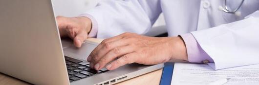 Hands typing on a laptop