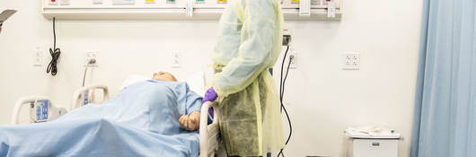 Doctor standing over patient in a hospital