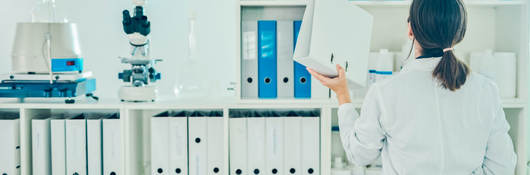 Lab tech putting away a binder on a shelf