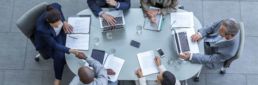 Overhead view of business people sitting around a conference table while working