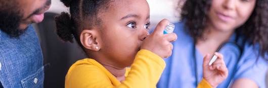 Child using an inhaler with the help of a doctor