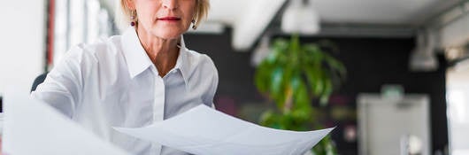 Manager reviewing reports by laying them out on a table