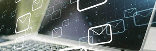 An open laptop with email icons overlaid across it
