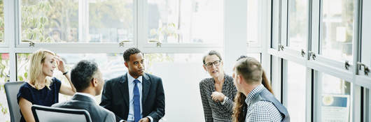 Group of business professionals having a discussion while sitting in a circle