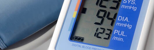 Picture of blood pressure monitor with a reading displayed.
