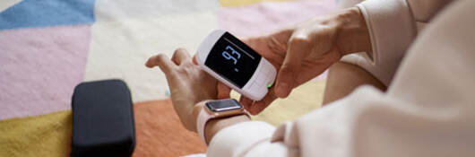 Person using a digital device to check their blood sugar