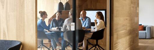 Business executives meeting inside a modern wood paneled conference room