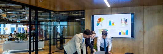 Three business colleagues reviewing metrics in a meeting