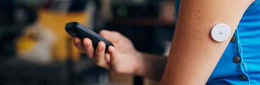Person testing their blood sugar with wireless medical device