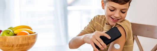 Child using a mobile device to check blood sugar levels
