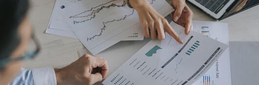 Group of people meeting and discussing graphs