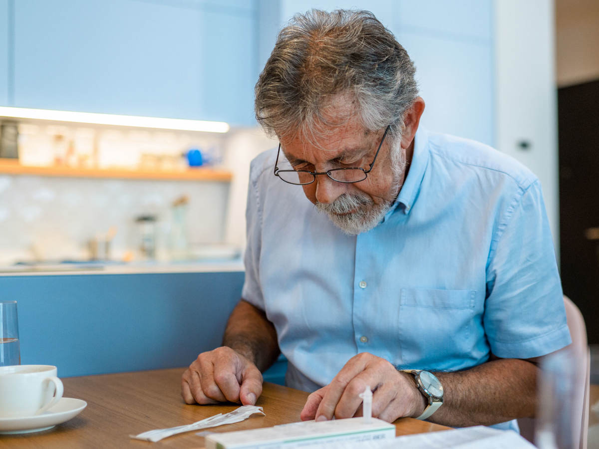 Man reading covid test kit instructions