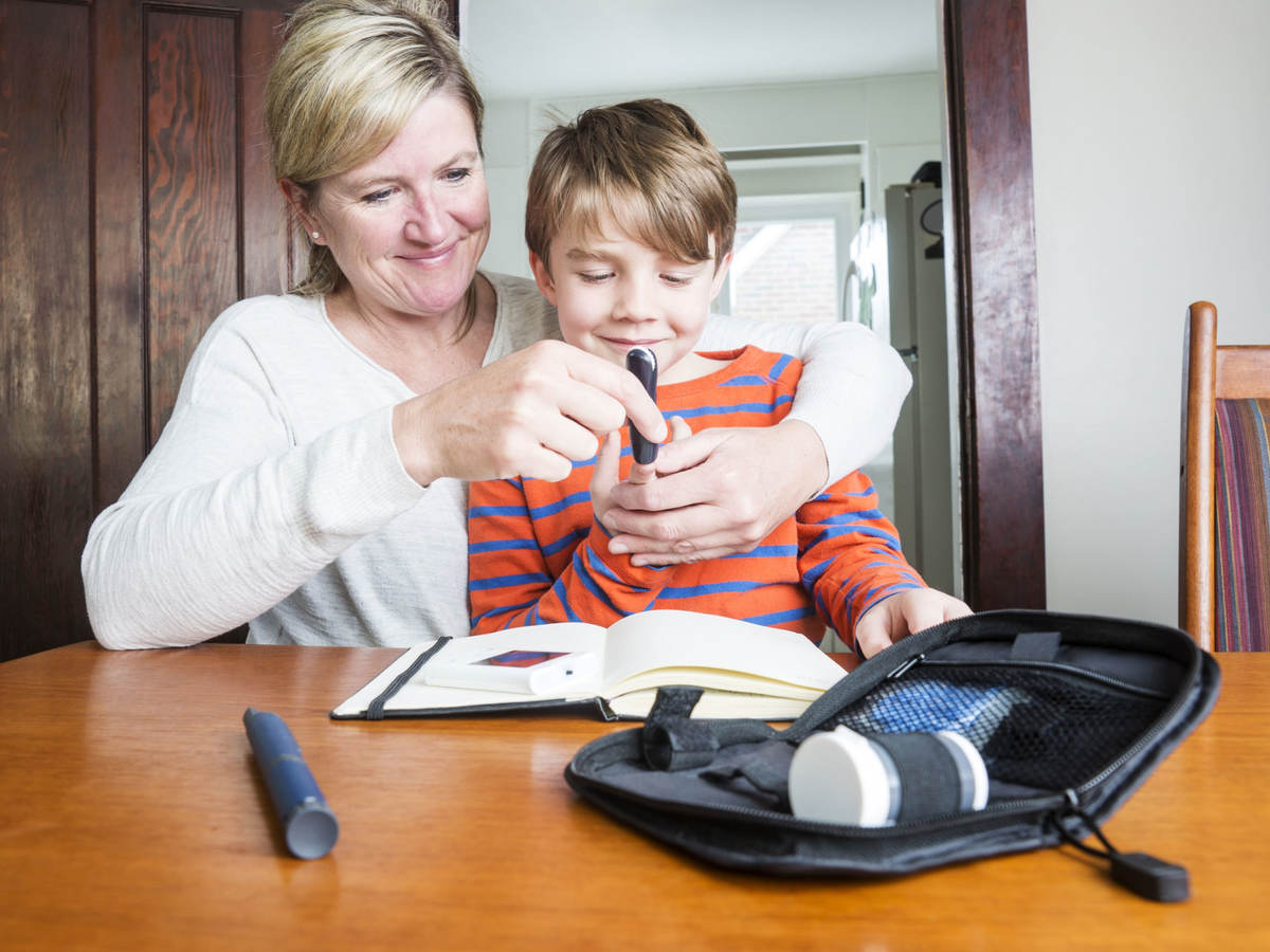 Mother helping son use medical device