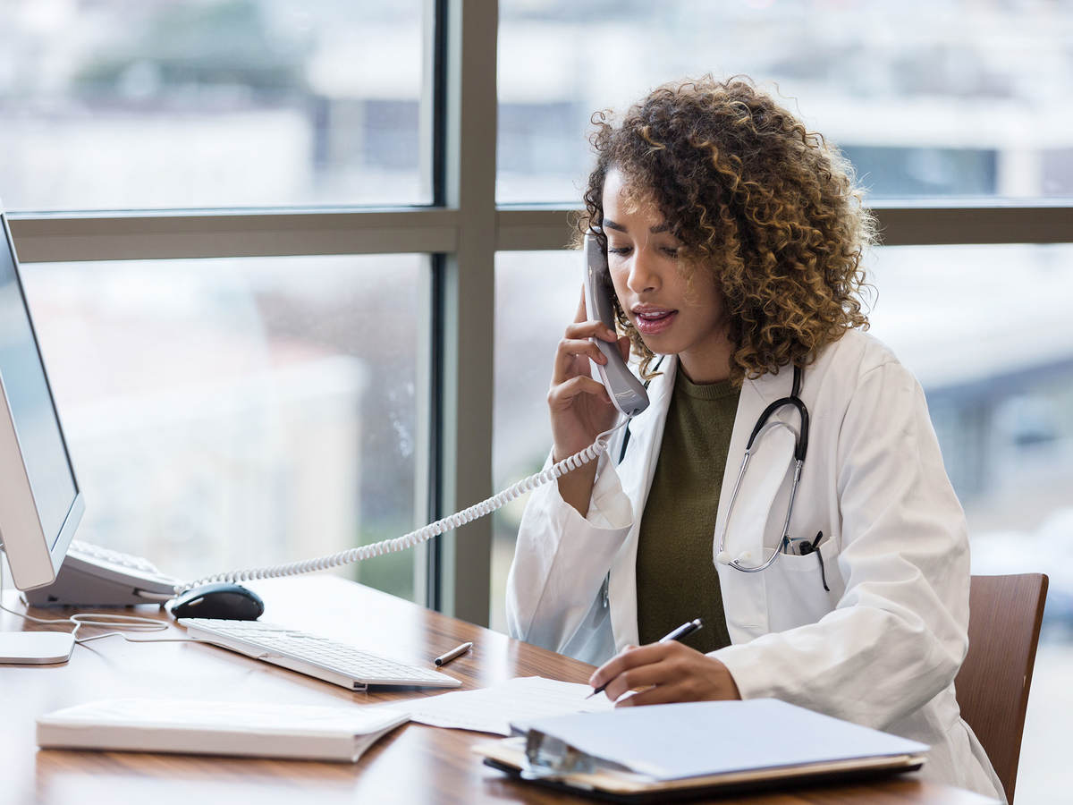 Doctor sitting at desk on the phone