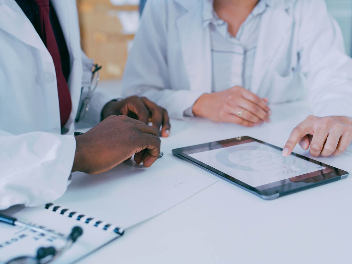 Two medical professionals using a digital tablet