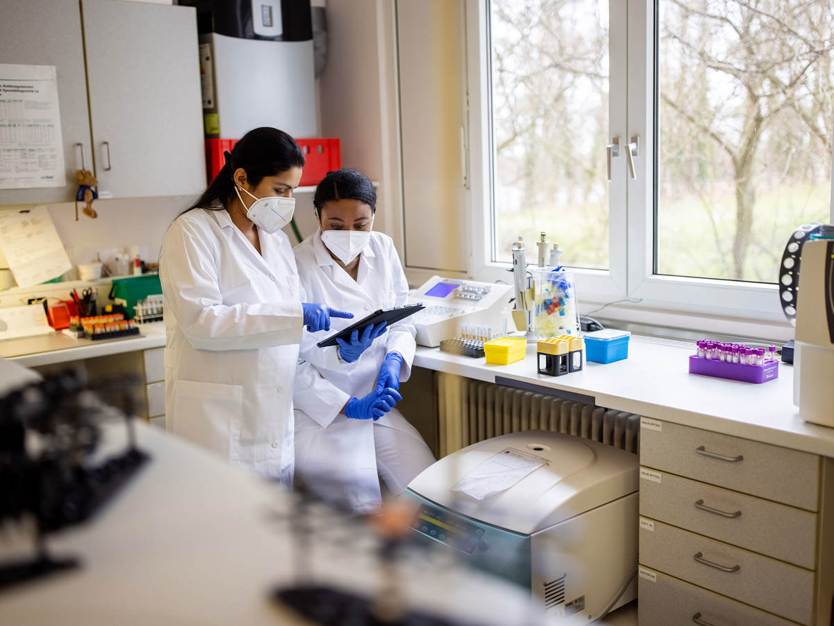 Two lab technicians looking at a clipboard