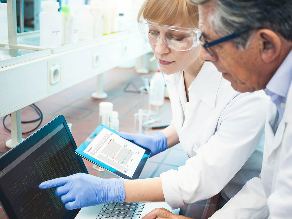 Two lab technicians looking at data on a computer