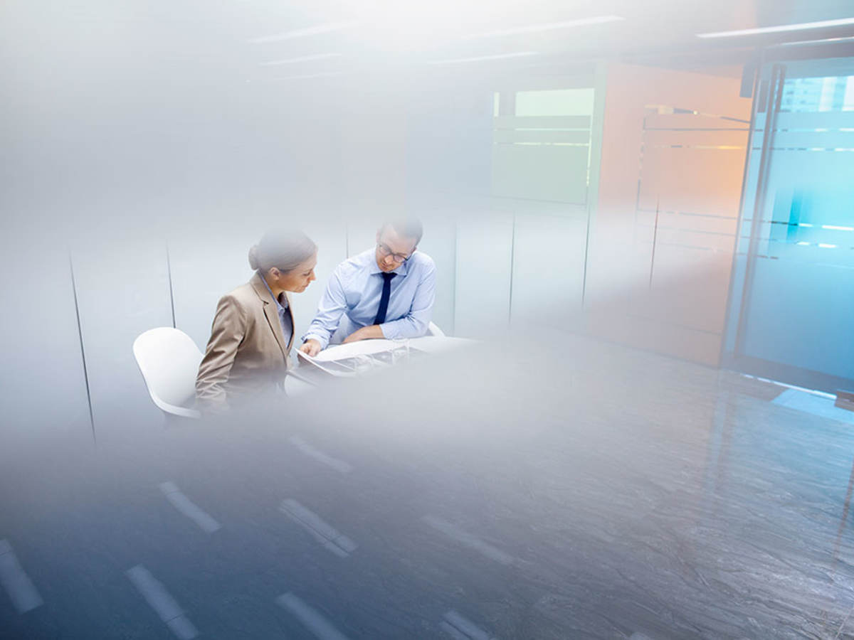 Two people reviewing a document in a conference room