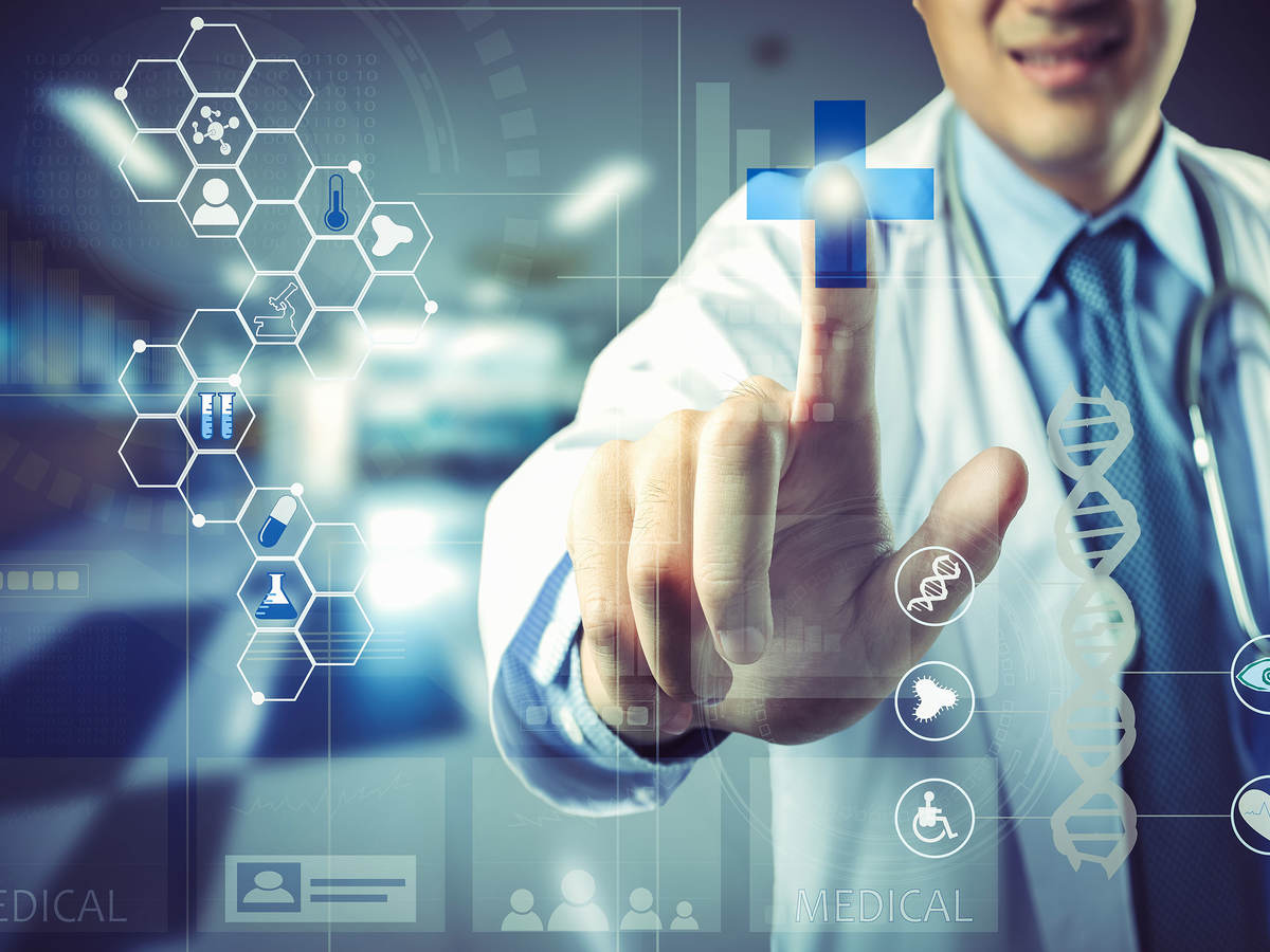 Doctor pointing to a blue cross on a high tech screen