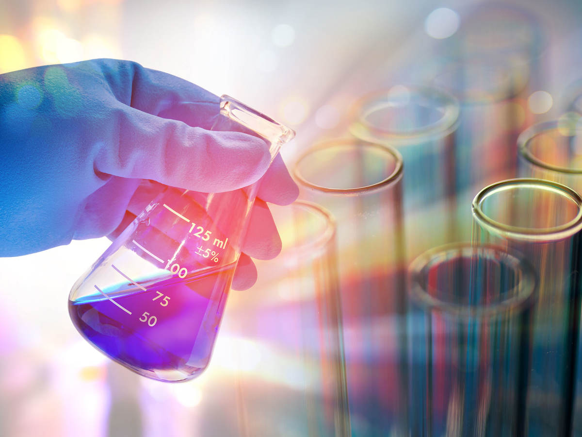 Person looking at blue liquid in an Erlenmeyer flask