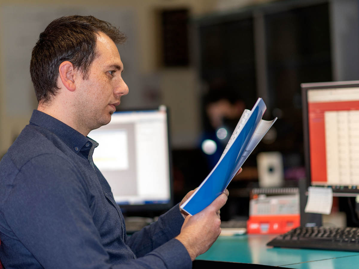 Person standing at a desk looking at documents