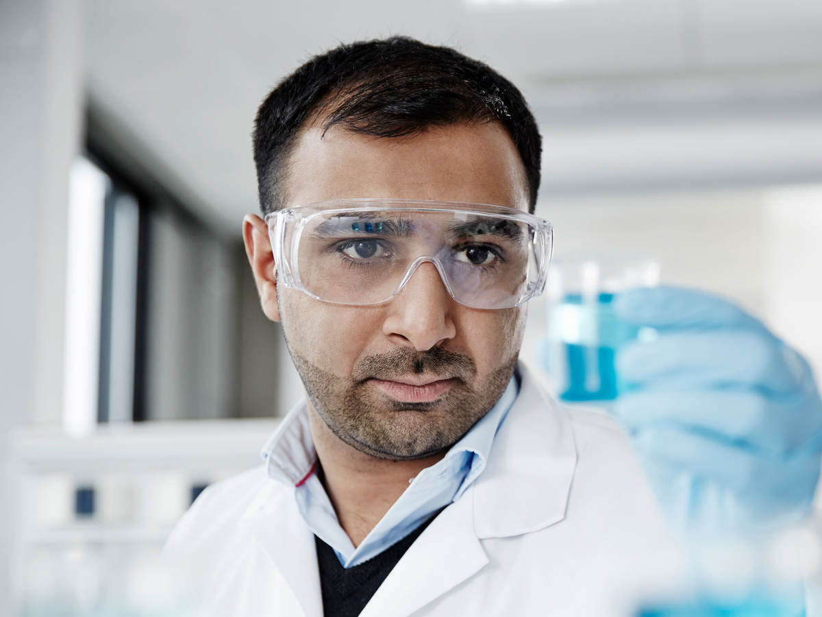 Lab technician holding a beaker with liquid