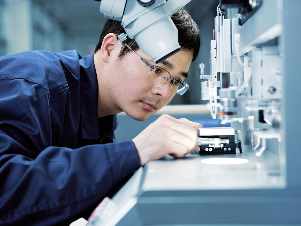 Lab technician placing something under a microscope