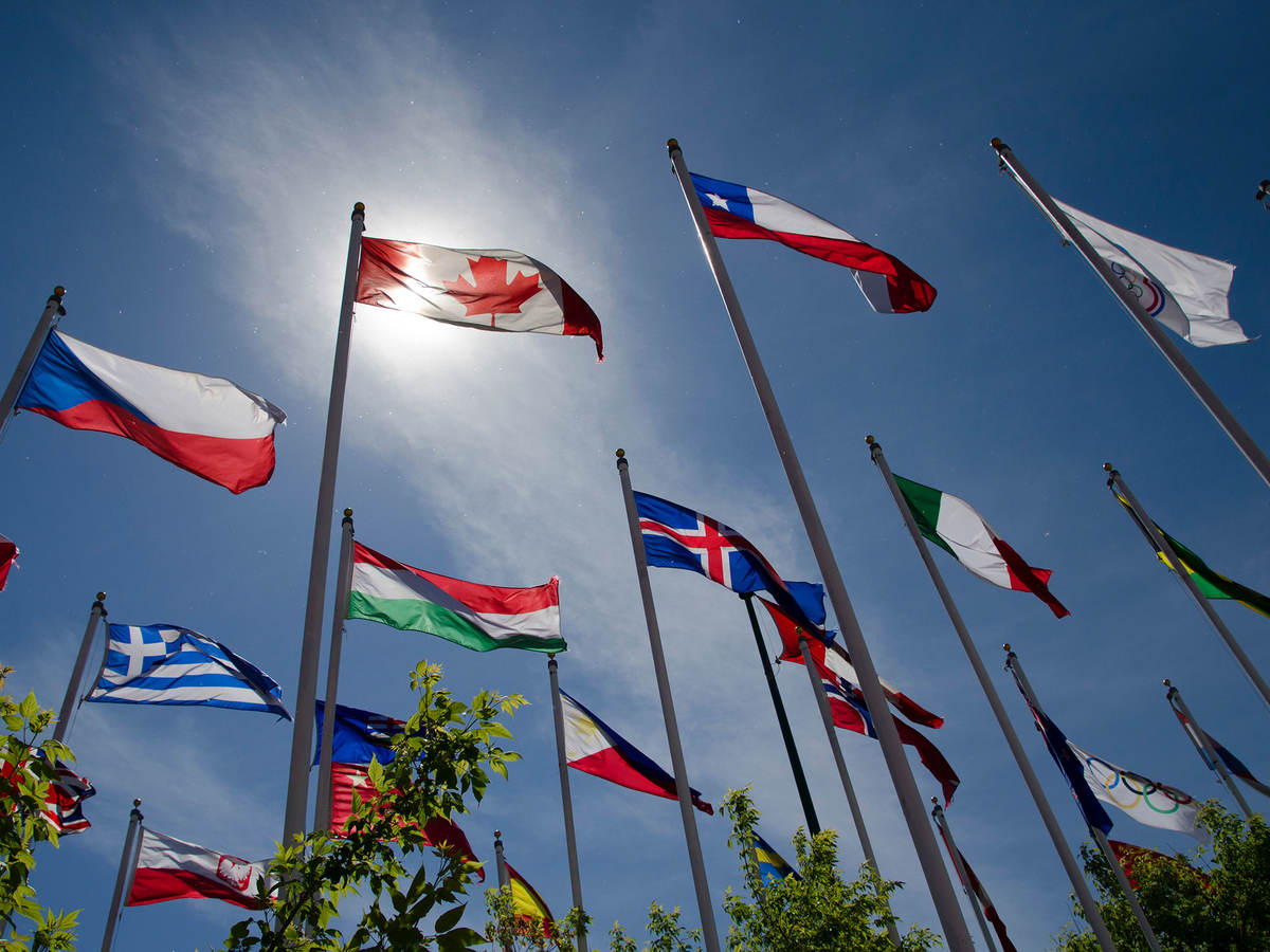 Photo of flags from around the world flying in the wind