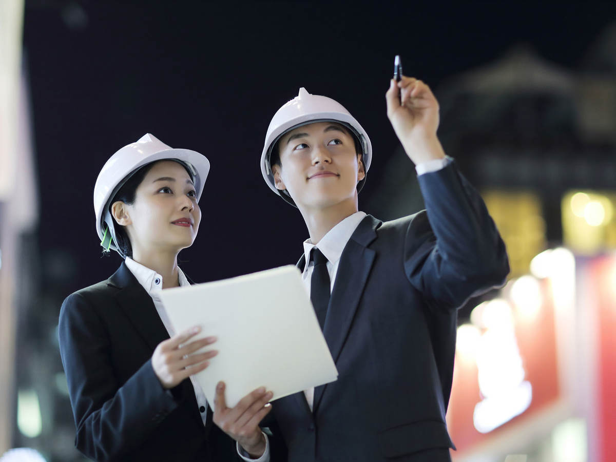 Two people in hardhats interacting