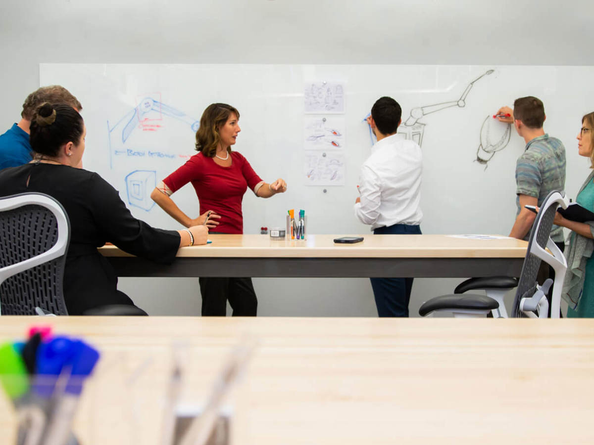 People gathered around a whiteboard having a meeting