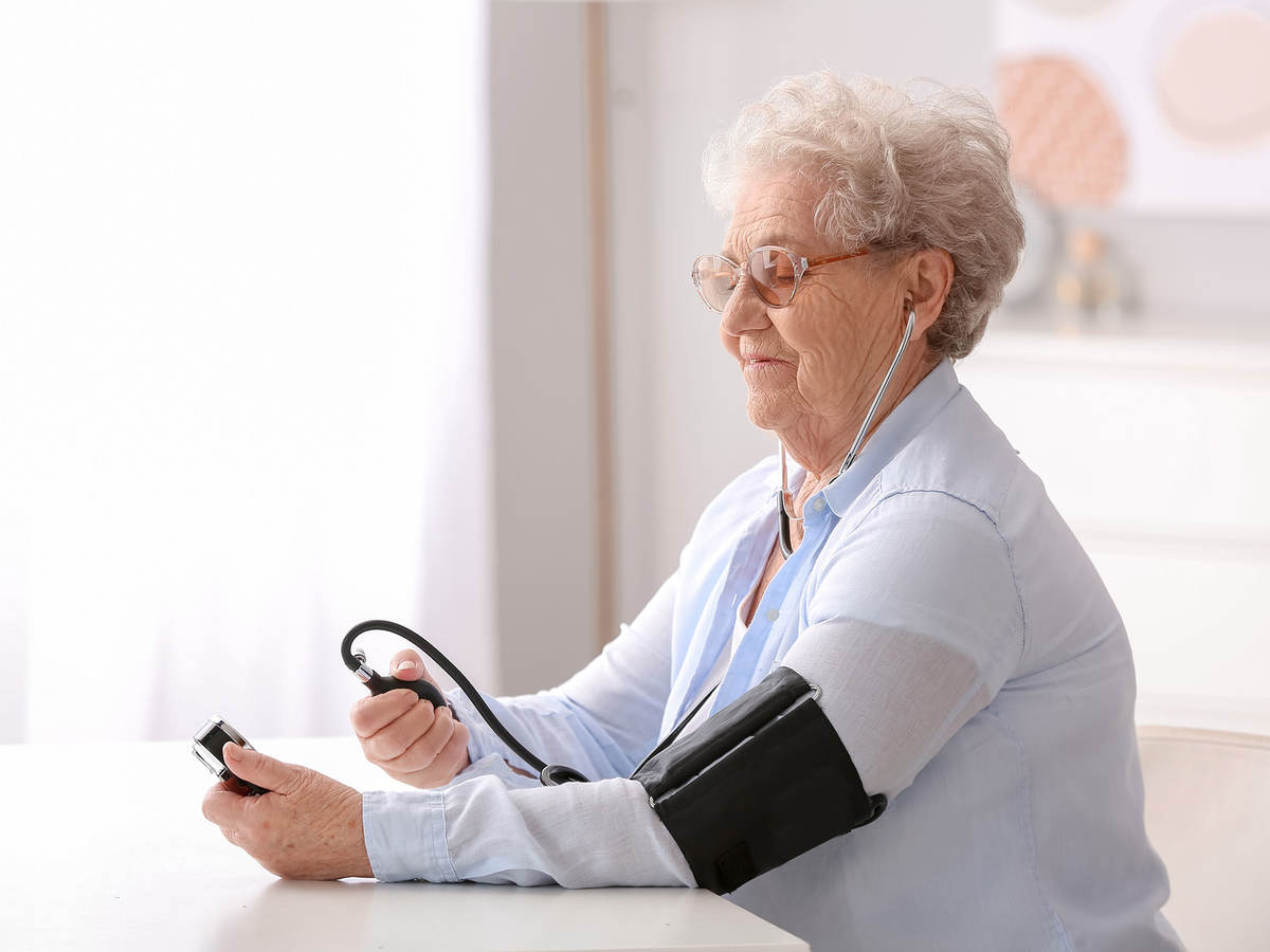Elderly person measuring their blood pressure