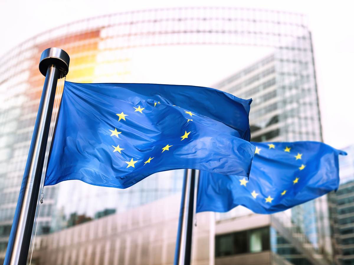 Two EU flags flying in the wind