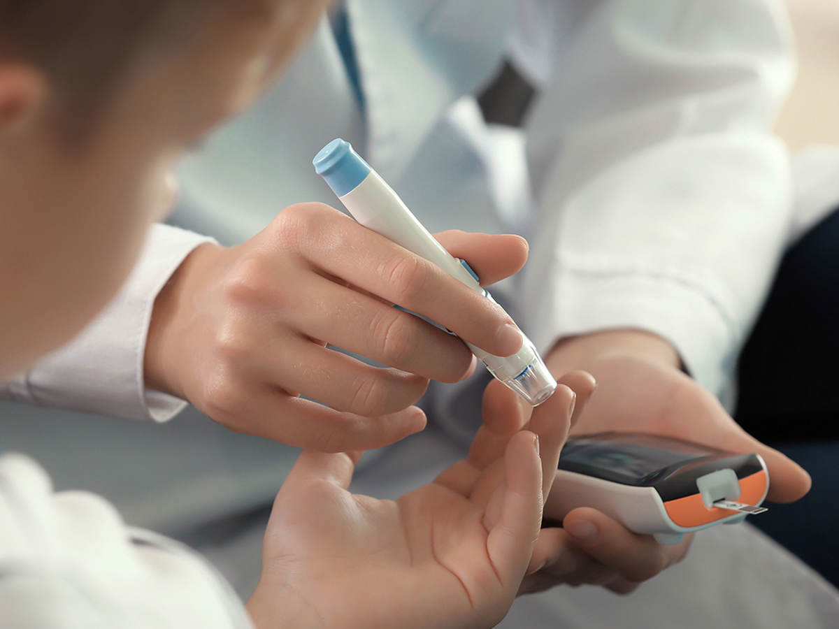 Doctor administering a blood sugar test on a patient