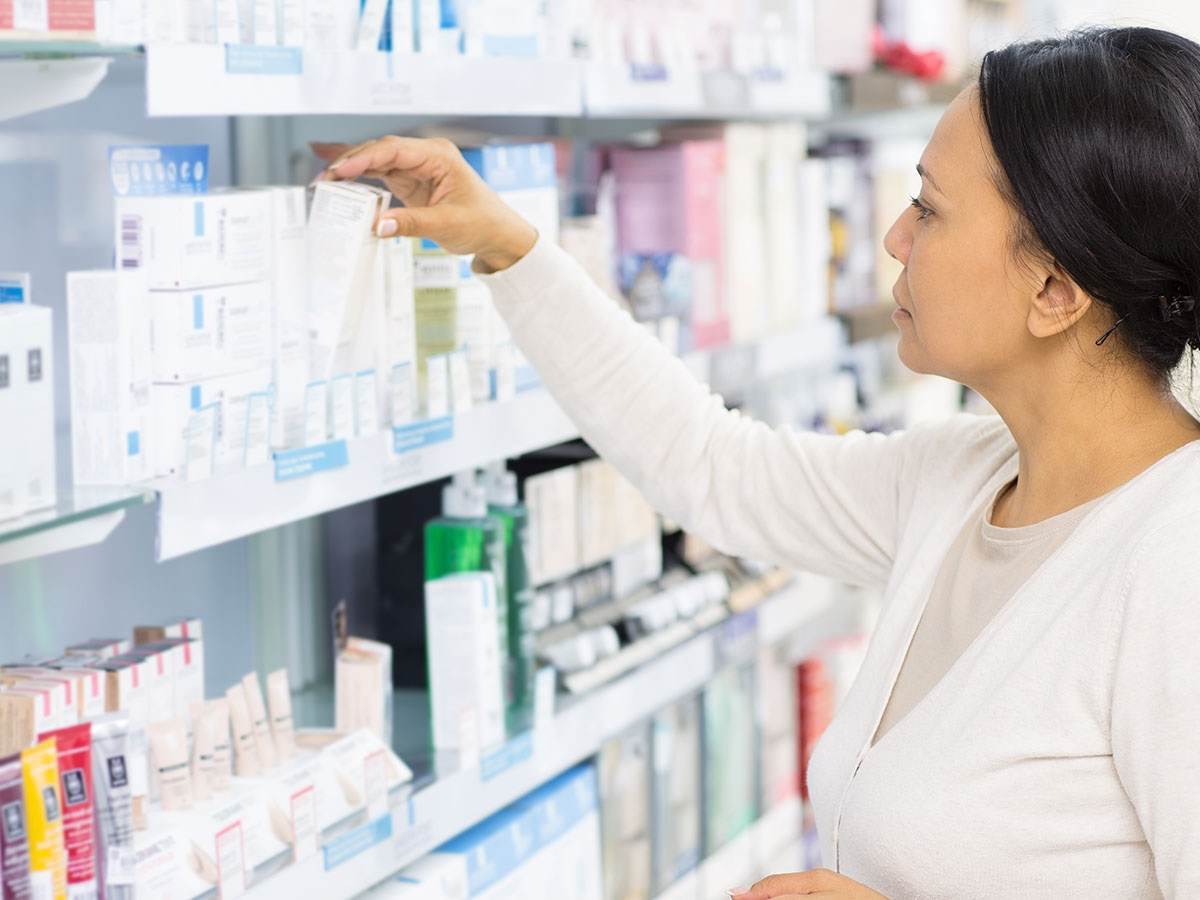 Customer grabbing medicine off the shelf at a store