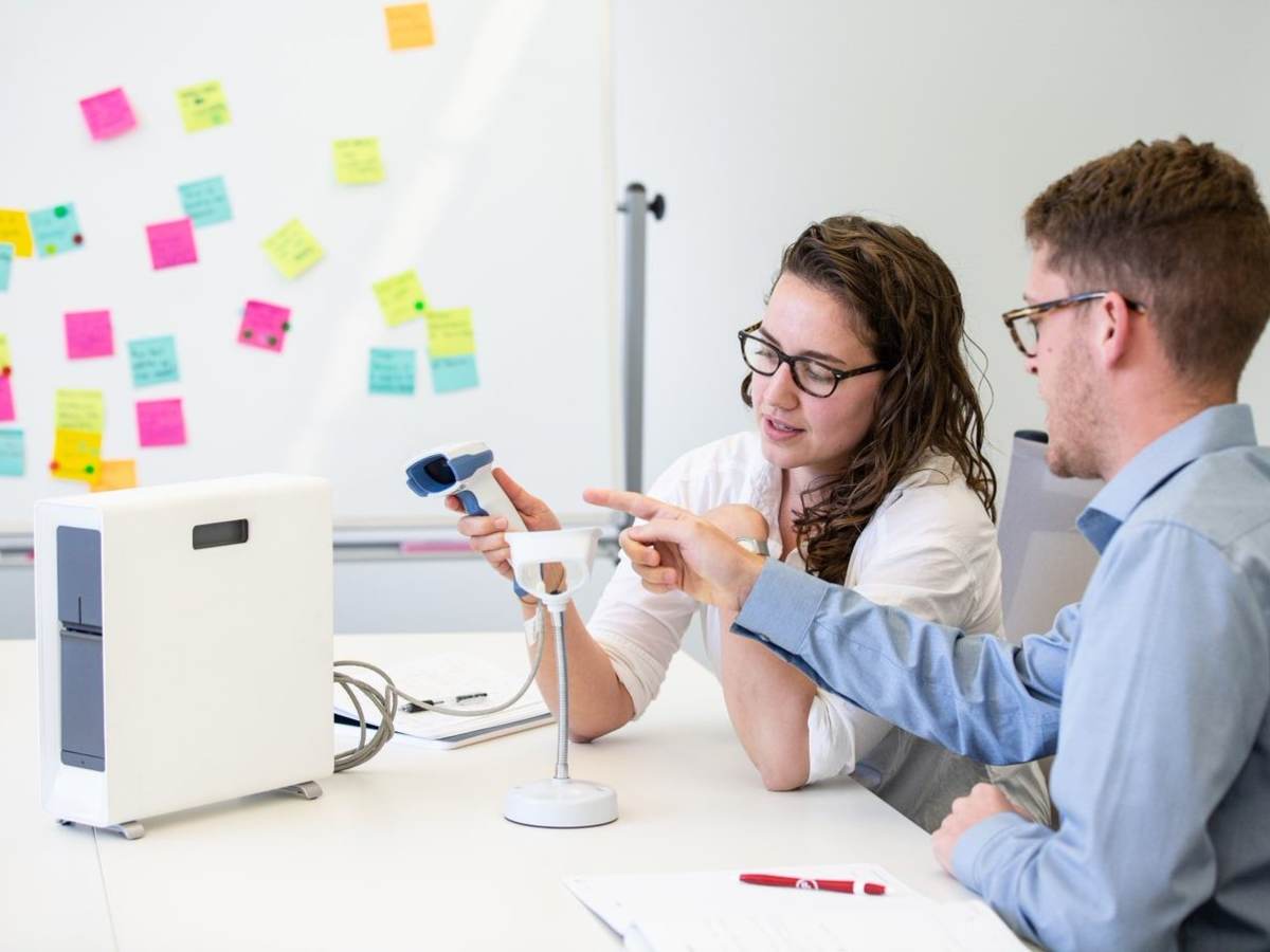 Two people in a conference room testing medical equipment