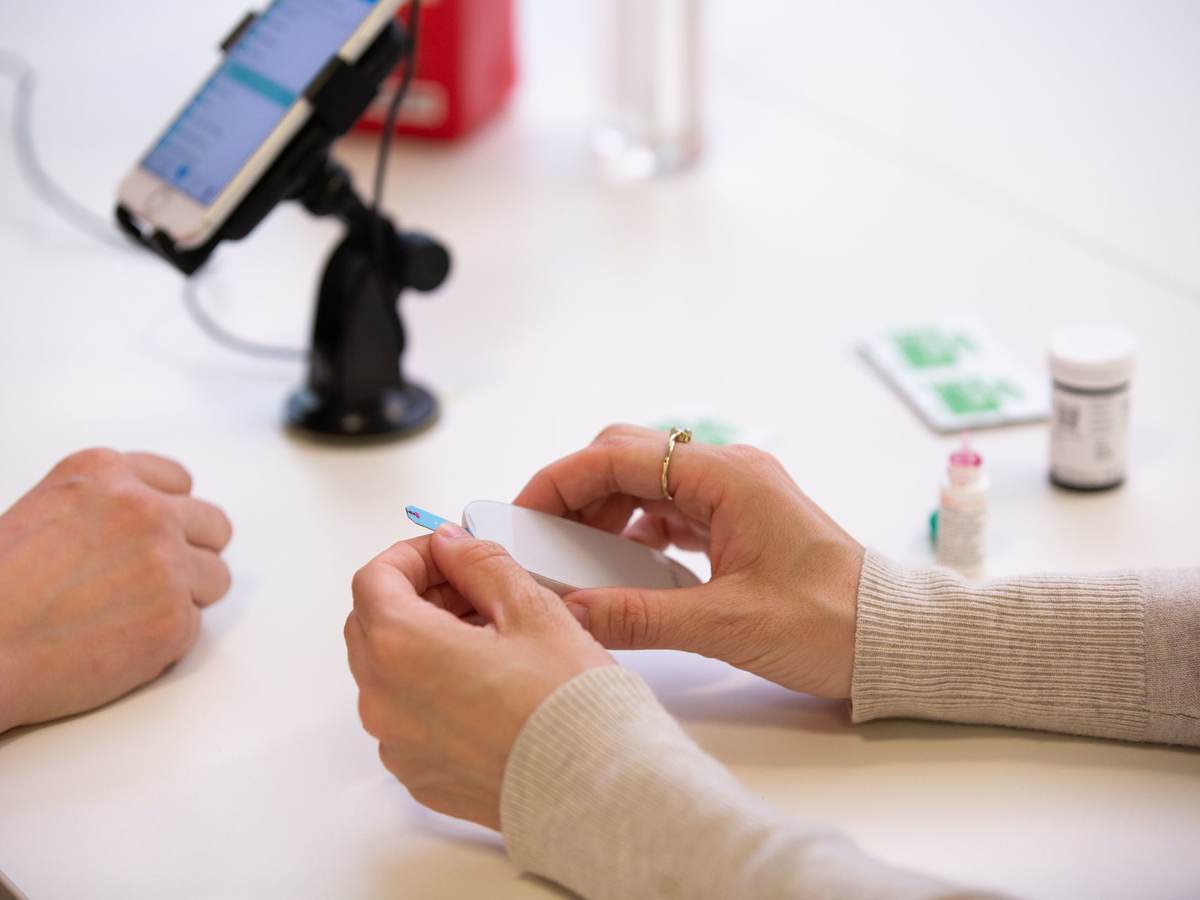 Person pulling a test strip out of a machine