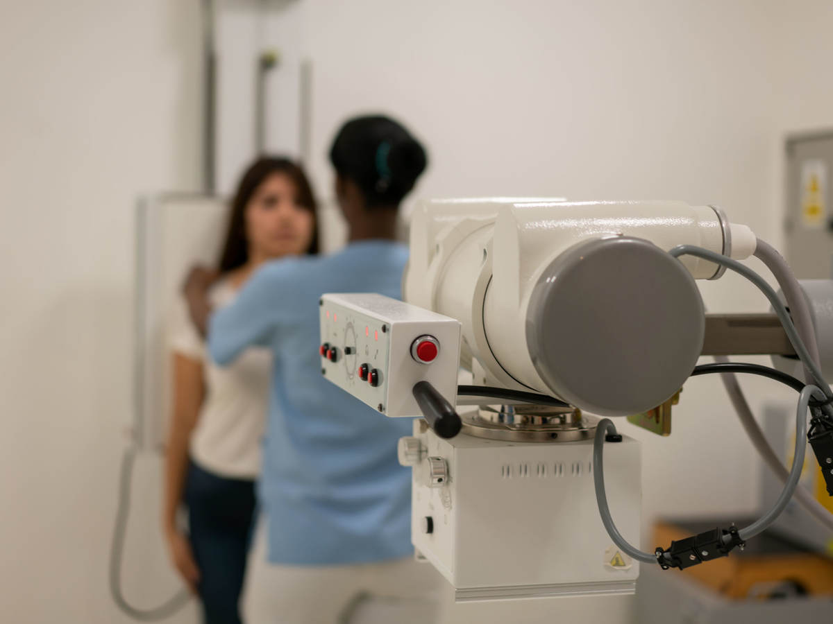 Nurse aligning a patient in order to take an x-ray