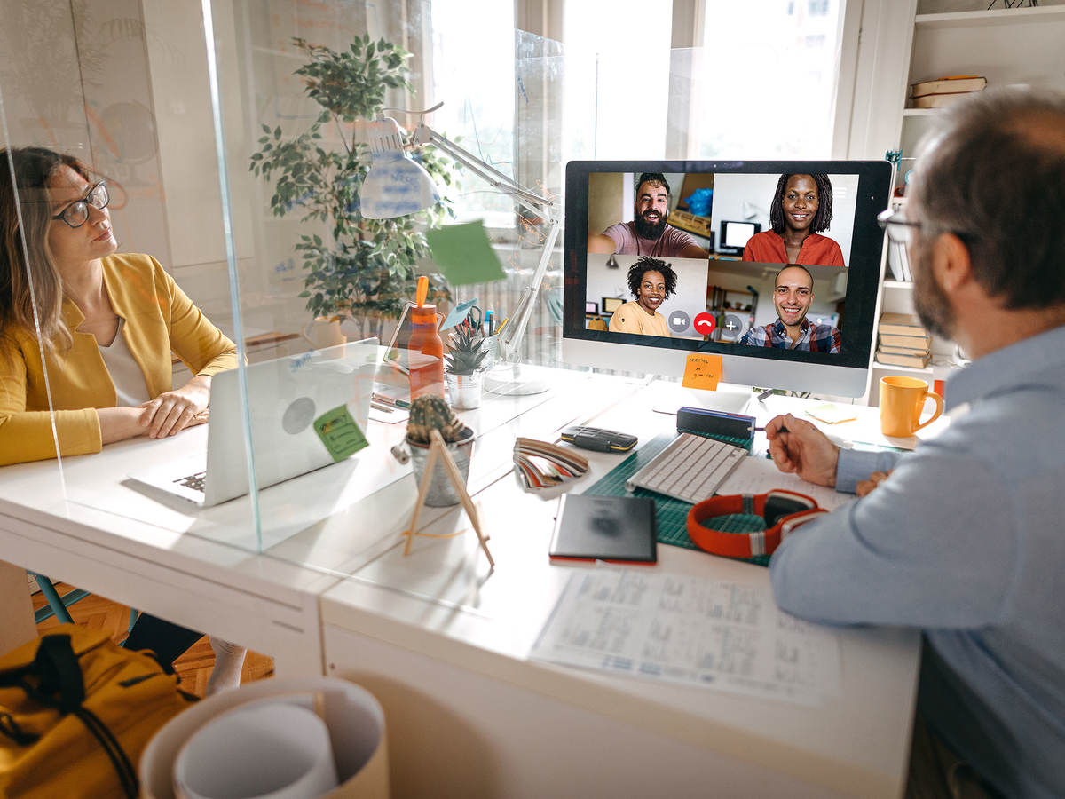 Two people sitting at a desk on a video call