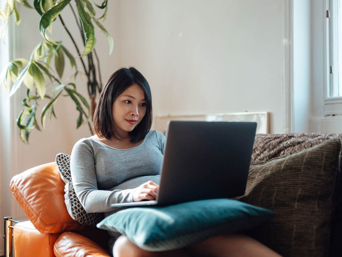 A person sitting on couch using their laptop