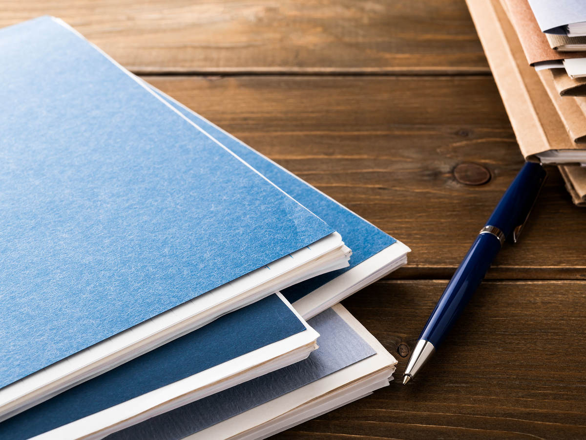 Folders, pen, and notepads on a table