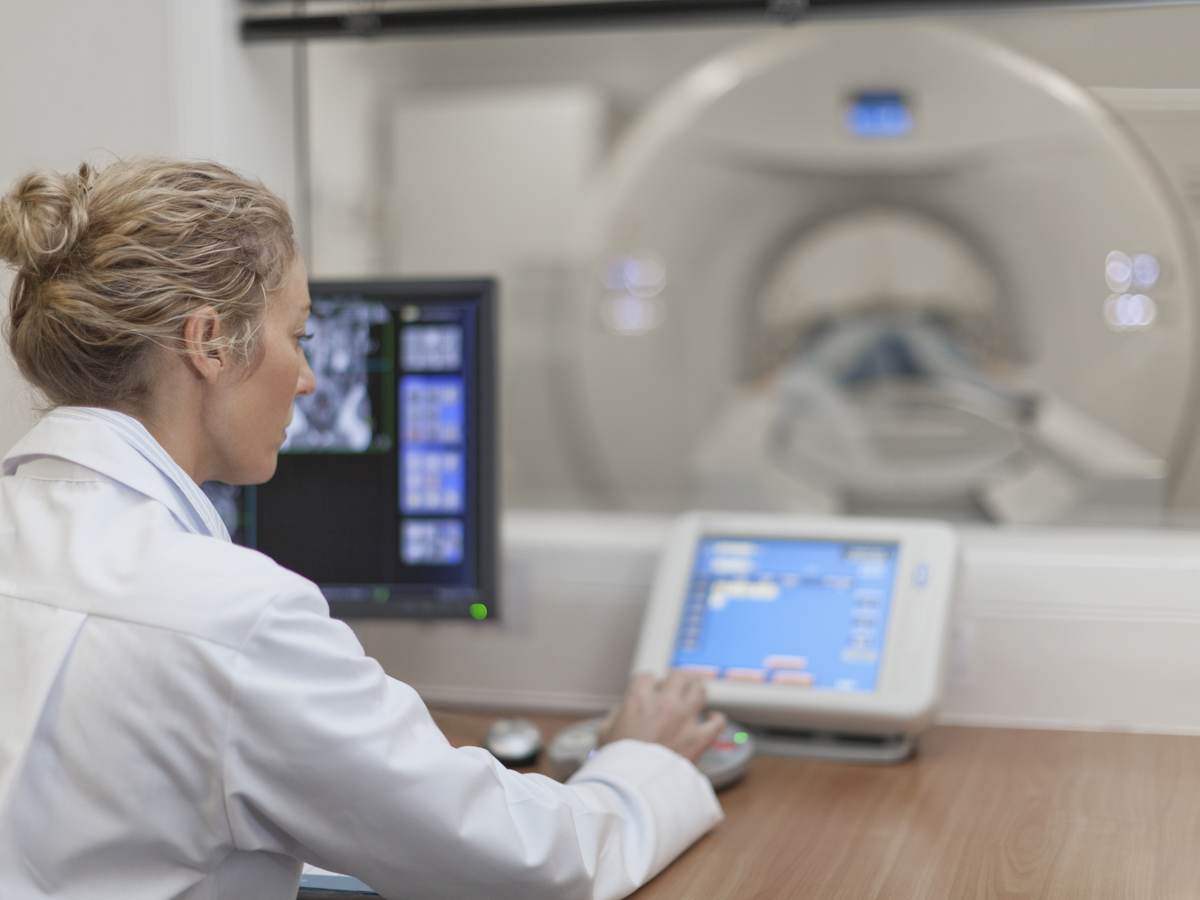 Medical professional using electronic controls to test a medical scanning device.