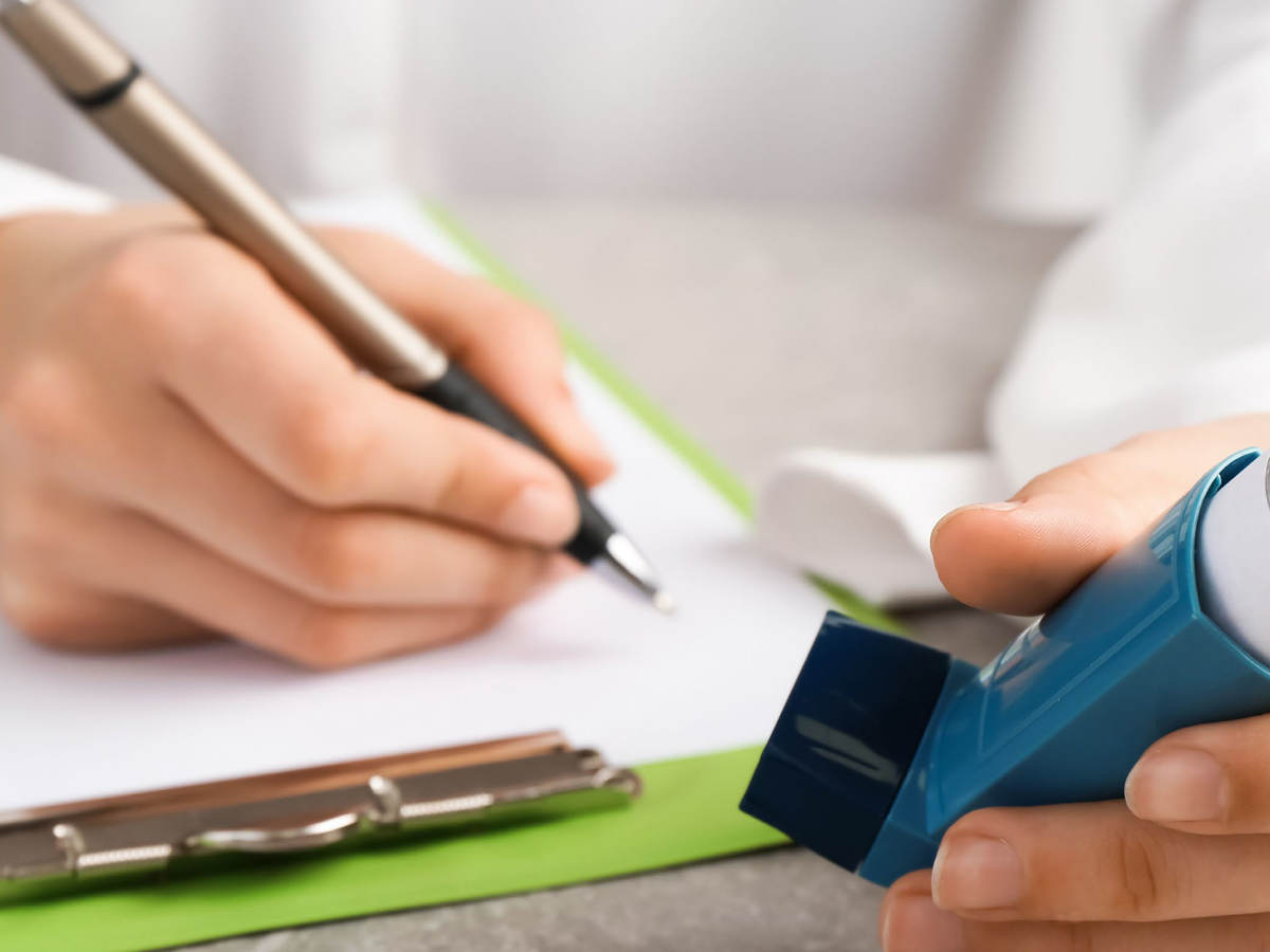 Person taking notes on a clipboard while holding a nebulizer