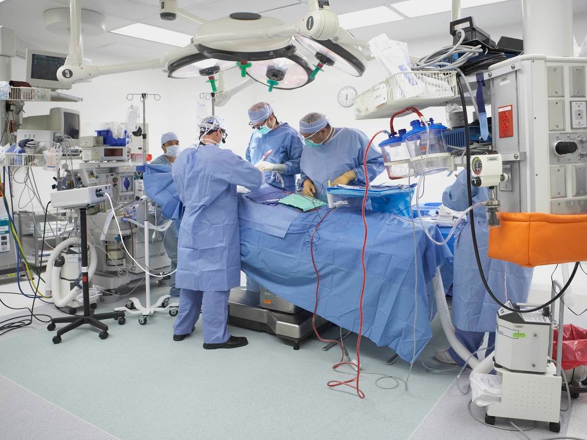 Five surgeons operating on a patient